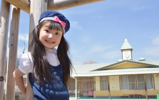 保育園の庭で笑う少女